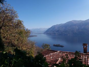 High angle view of lake and mountains against clear blue sky