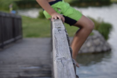 Low section of woman standing by tree against sky