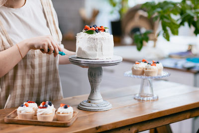 Midsection of chef picking cake