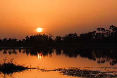 Scenic view of lake against orange sky