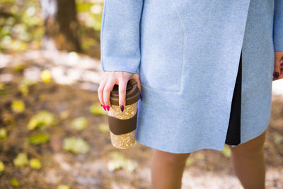 Midsection of woman holding ice cream standing outdoors