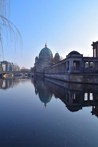 Spree river by berlin cathedral against clear sky