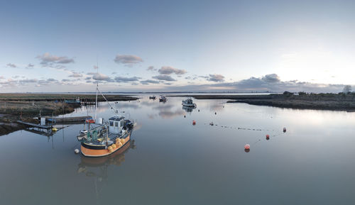 Boats moored in lake against sky