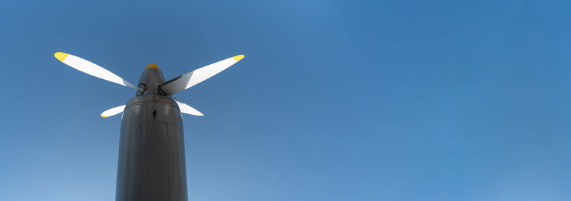 Low angle view of windmill against clear blue sky