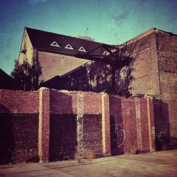 View of brick wall with buildings in background