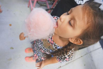 High angle view of girl eating cotton candy