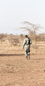 Rear view of siblings running on field