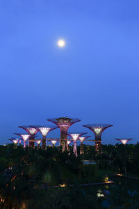 Illuminated street light against sky at night