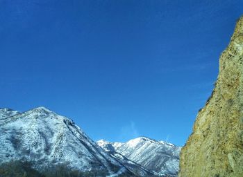 Scenic view of snowcapped mountains against clear blue sky