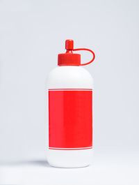 Close-up of red bottle against white background