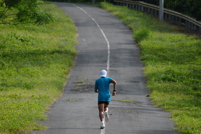 Rear view of man running on road