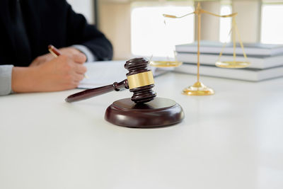 Midsection of lawyer with gavel at table