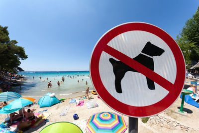 Information sign with people in background at beach