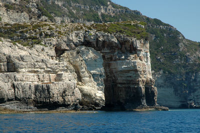 Scenic view of rock formation in sea against sky