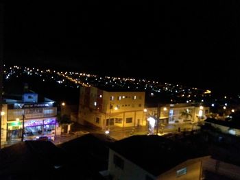 High angle view of illuminated buildings against sky at night