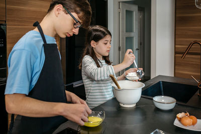 Side view of woman preparing food at home