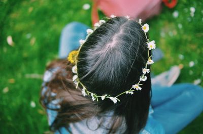 High angle view of woman wearing tiara while sitting on grass