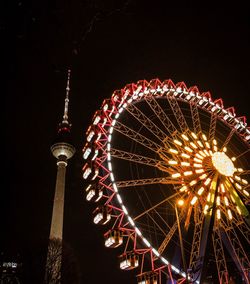 Low angle view of illuminated ferris wheel at night