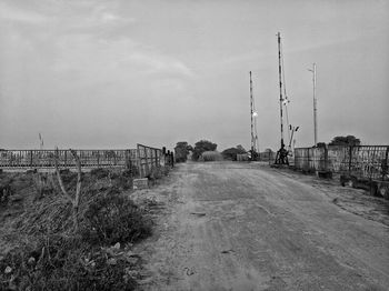 Road amidst field against sky