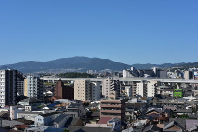 High angle view of buildings against clear blue sky