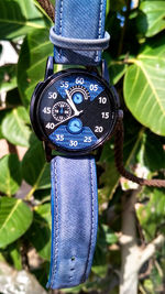 Close-up of clock against blue sky