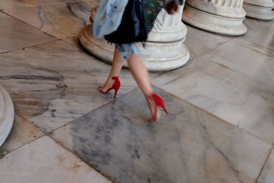 Low section of woman walking on tiled floor