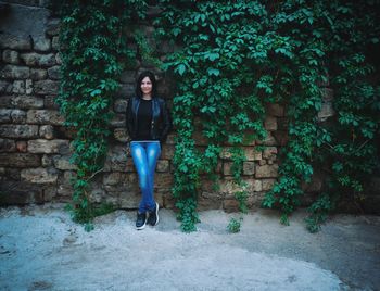 Portrait of woman standing against wall