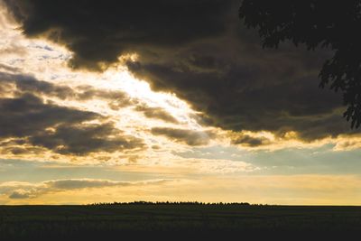 Scenic view of silhouette field against sky during sunset