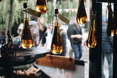 Close-up of olive oil bottles with labels hanging at store