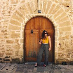 Full length of woman standing against wall