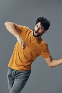 Portrait of young man standing against white background