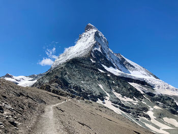 Scenic view of snowcapped mountains against clear blue sky