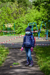 Full length of girl standing against plants at park