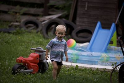 Portrait of boy playing with toys on field