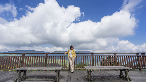 Rear view of woman standing on wooden wall