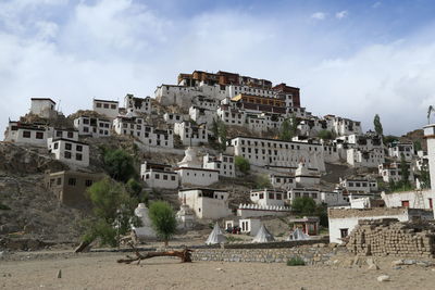 Buildings in town against cloudy sky