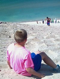 Rear view of boy standing on beach