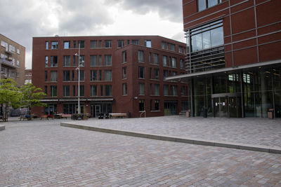 Street by buildings in city against sky