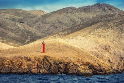 Red lighthouse in front of river