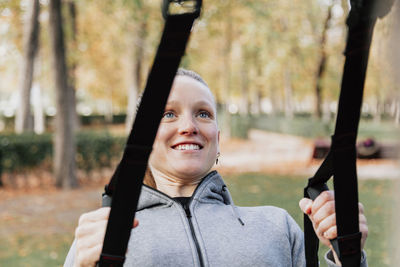 Close-up of smiling woman exercising at park