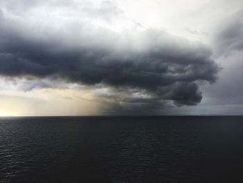 Scenic view of sea against storm clouds