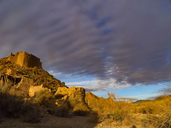 Scenic view of rock formation amidst buildings against sky