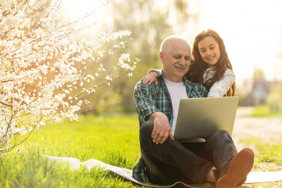 Smiling child hugging her happy grandfather - outdoor in nature.