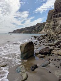 Rocks on sea shore against sky