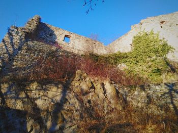 Low angle view of old building against clear blue sky