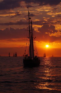 Sailboat in sea at sunset