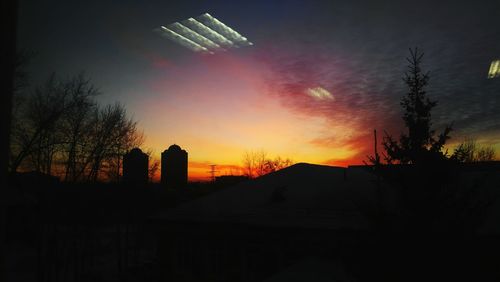 Low angle view of illuminated buildings against sky during sunset