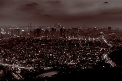 Aerial view of illuminated cityscape against sky at night