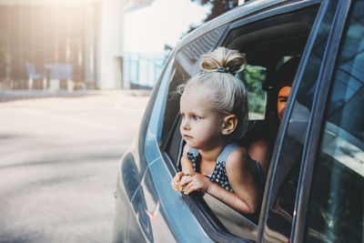 Portrait of boy looking through car window