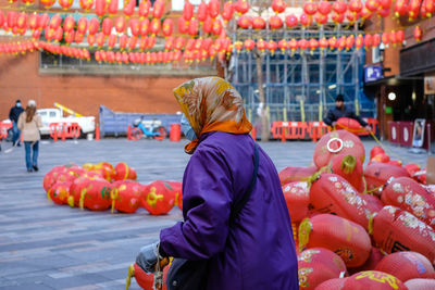 Rear view of lady with chat and scarf  at chinatown 